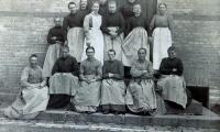 En gruppe kvindelige patienter - og en enkelt plejer i hvidt forklæde - omkring år 1900