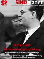 Sorthvidt billede af tidligere statsminister, Kampmann, med briller på og en tændt cigar i munden